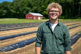 Eliudes Camps Marcano, an exchange student from Puerto Rico, stands in a field at the Kingman Research Farm, where he helped support agricultural research at UNH this past summer.